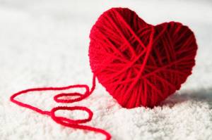 Red heart-shaped wool ball unraveling